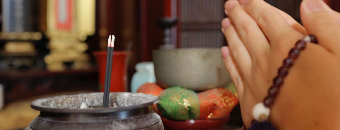 a buddhist praying in front of a buddhist altar